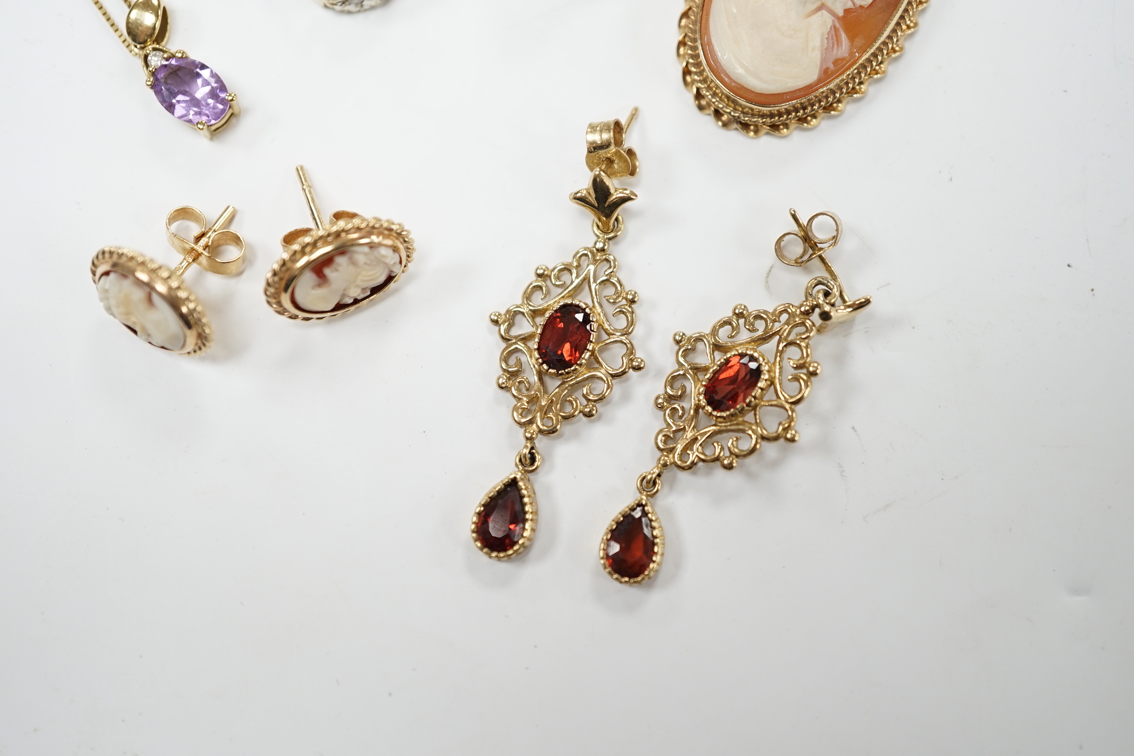 Two 9ct and gem set rings, including diamond chip and white opal, a 9ct and amethyst set pendant necklace, pair of 9ct gold and garnet earrings, a 9ct mounted cameo shell brooch and pair of matching earrings, gross weigh